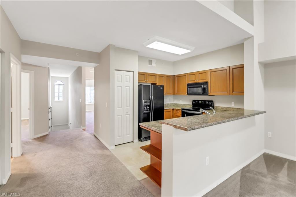 20160 Estero Gardens Circle, Unit 202 Estero, FL 33928 - Photo 3 of 44 a kitchen that has a refrigerator a stove and white cabinets