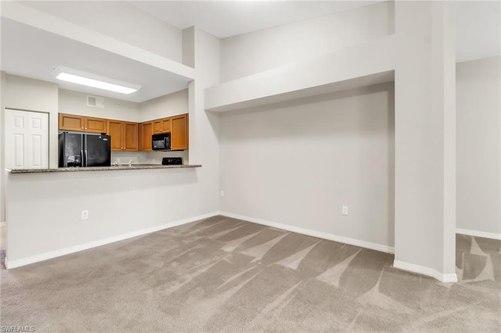 20160 Estero Gardens Circle, Unit 202 Estero, FL 33928 - Photo 8 of 44 a view of a kitchen with a sink and a microwave