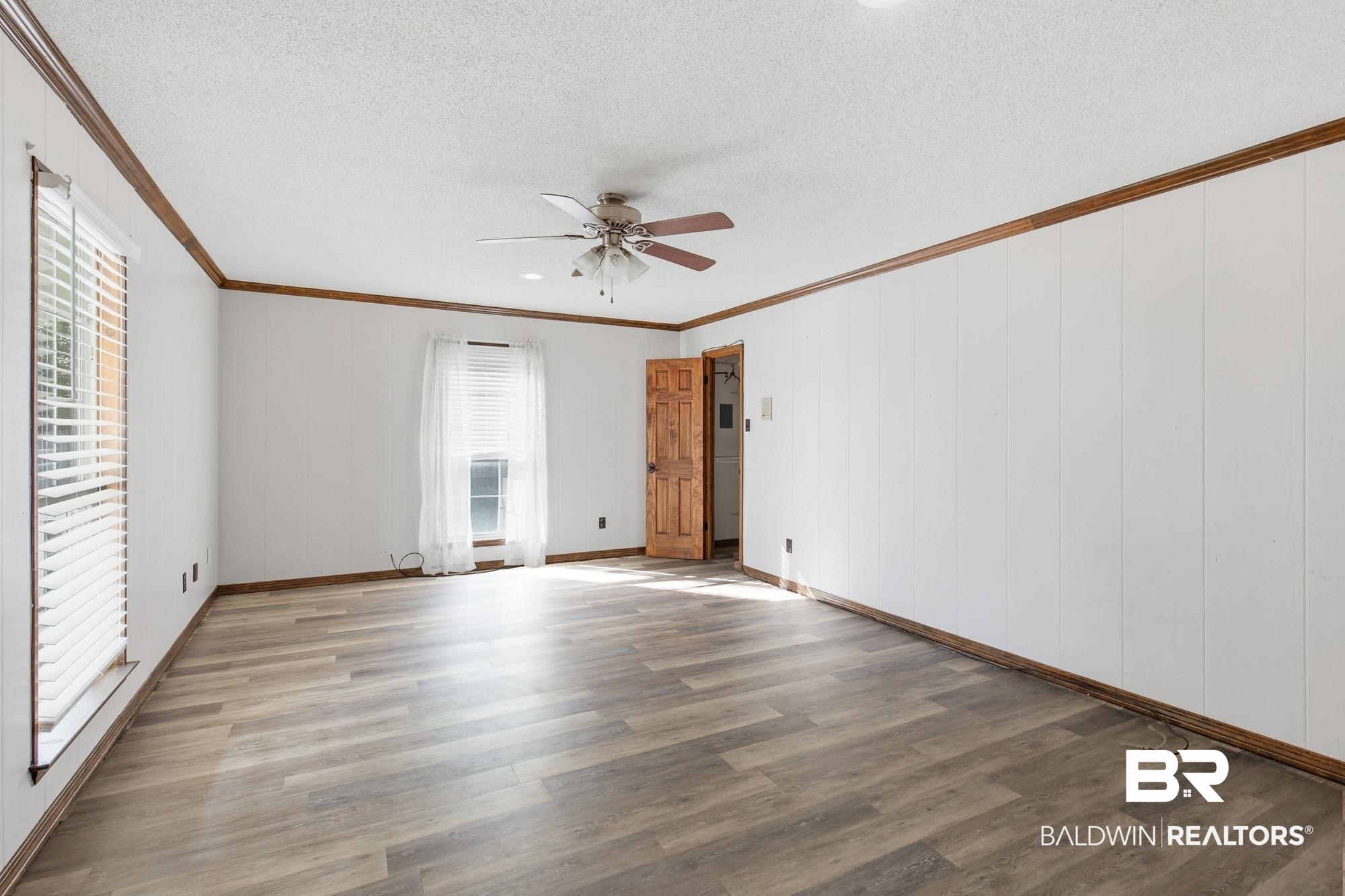 9215 Shiloh Drive Mobile, AL 36695 - Photo 14 of 32 Spare room with a textured ceiling, ornamental molding, wood finished floors, ceiling fan, and wooden walls