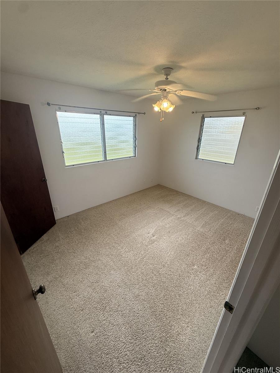 17-303 Pilikino Road Kurtistown, HI 96760 - Photo 17 of 19 an empty room with windows and fan