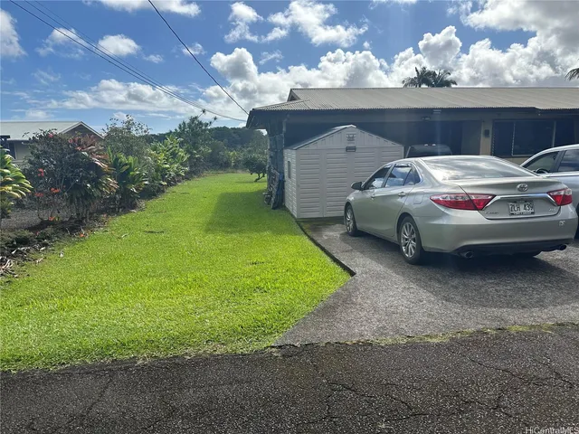 a car parked in front of a house with a big yard