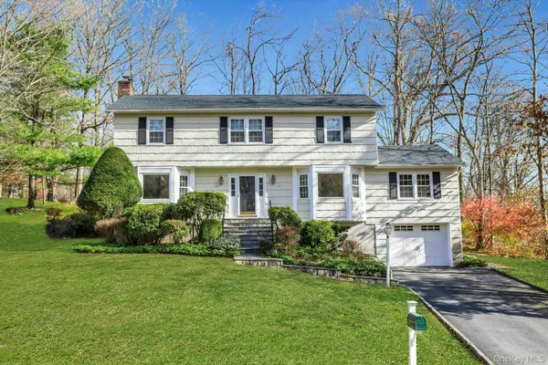 a front view of a house with a garden and plants