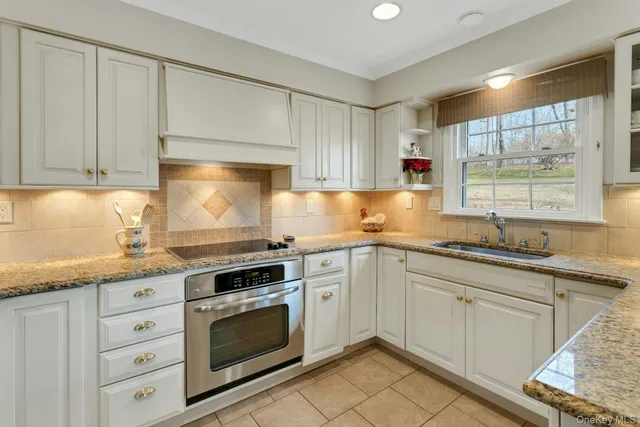 a kitchen with granite countertop white cabinets and white appliances