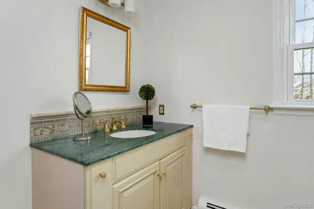 a bathroom with a granite countertop sink and a mirror