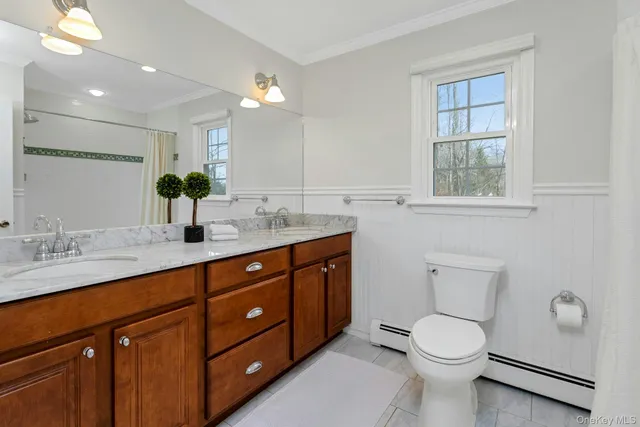a spacious bathroom with a double vanity sink toilet and a mirror