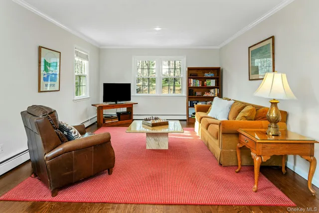 a living room with furniture a flat screen tv and a window