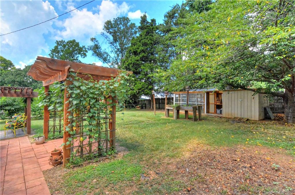 5700 Paw Creek Road Charlotte, NC 28214 - Photo 19 of 19 a view of a backyard with table and chairs under an umbrella