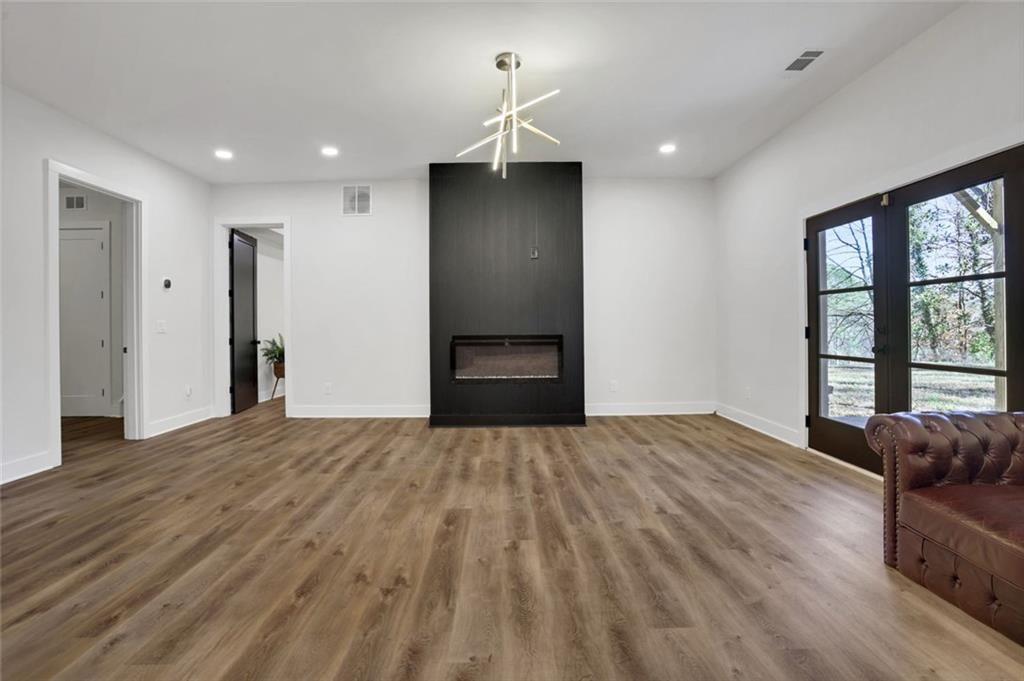 1200 Moores Mill Road Northwest Atlanta, GA 30327 - Photo 14 of 73 a view of an empty room with wooden floor and a cabinet