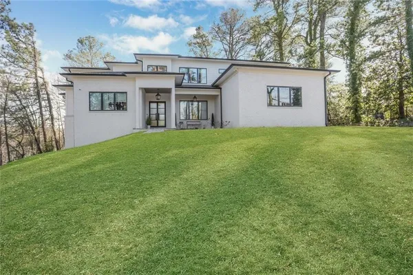 a view of a house with a big yard and large tree