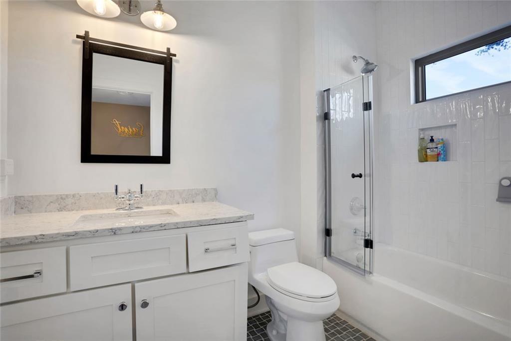 1200 Moores Mill Road Northwest Atlanta, GA 30327 - Photo 54 of 73 a bathroom with a granite countertop toilet a sink and a mirror