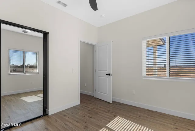 a view of an empty room with closet and a window