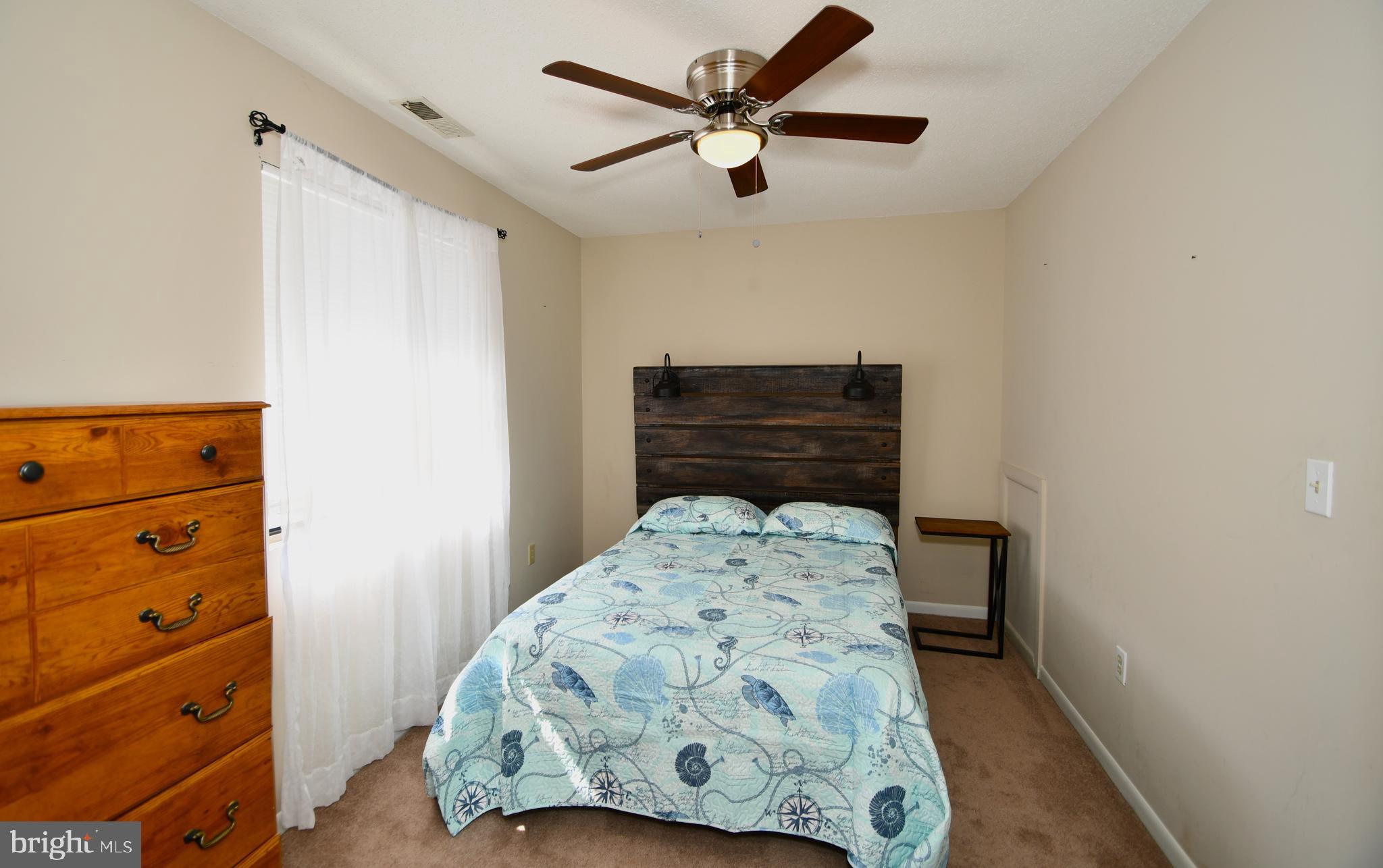 9815 Stephen Decatur Highway, Unit 3 Ocean City, MD 21842 - Photo 13 of 23 a bedroom with a bed and a dresser