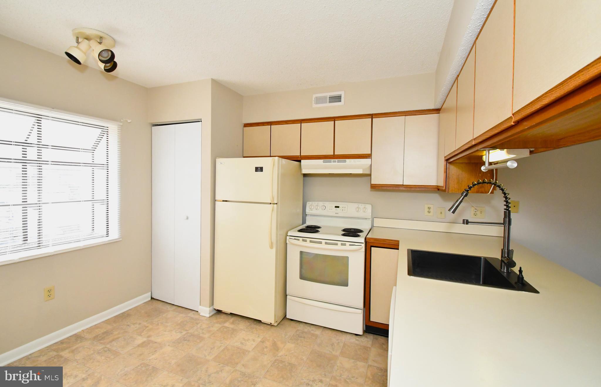 9815 Stephen Decatur Highway, Unit 3 Ocean City, MD 21842 - Photo 6 of 23 a kitchen with a stove a refrigerator and a sink