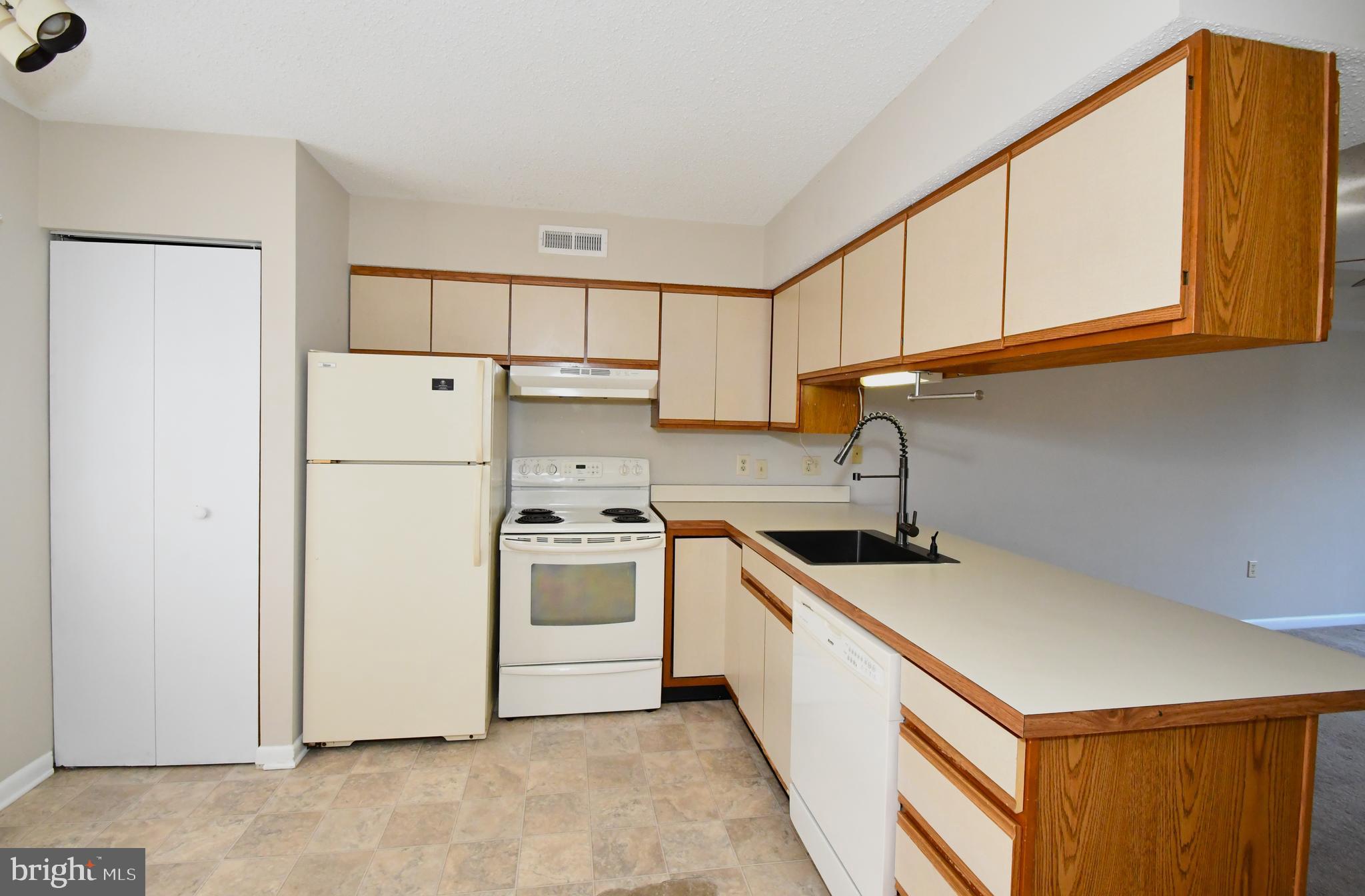 9815 Stephen Decatur Highway, Unit 3 Ocean City, MD 21842 - Photo 7 of 23 a kitchen with a sink a refrigerator and cabinets