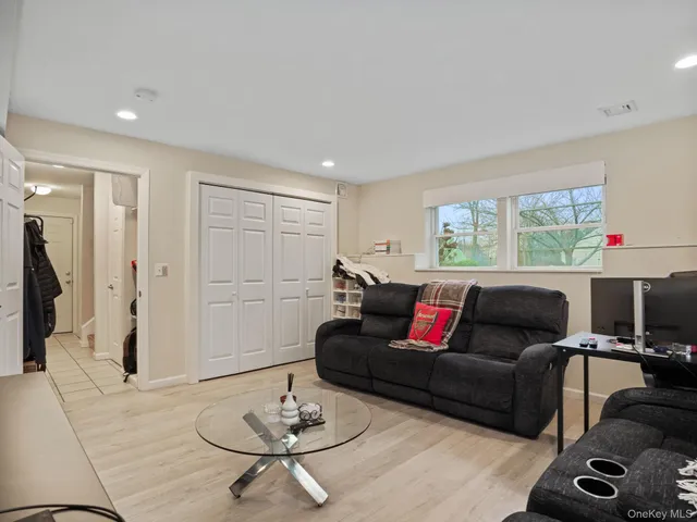 a living room with furniture and a dining table with wooden floor