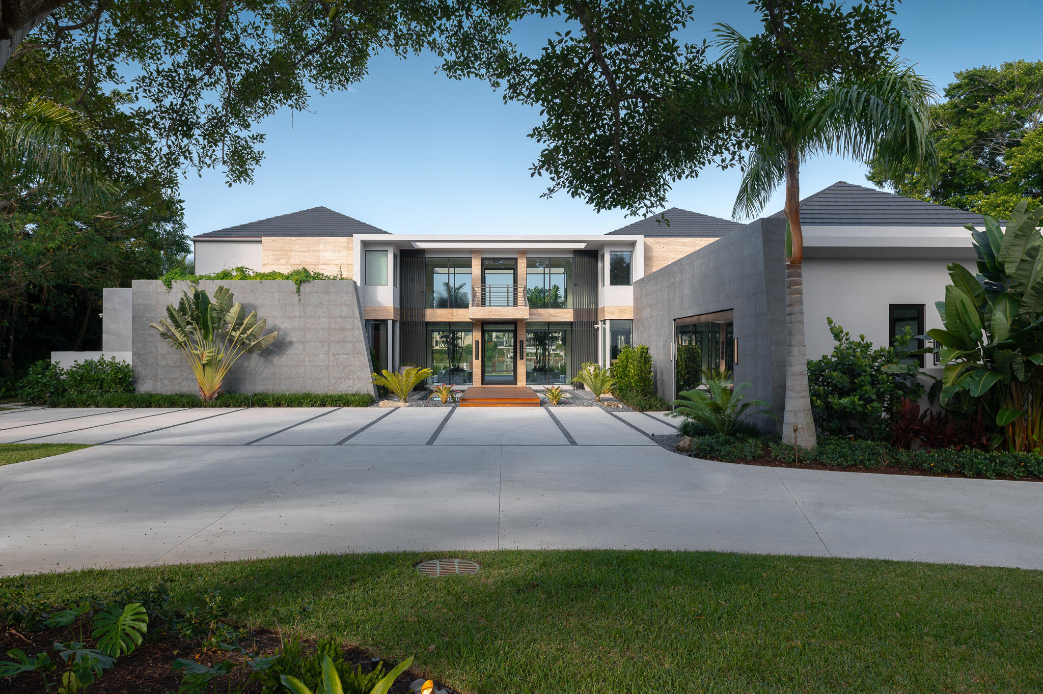 488 South Beach Road Jupiter Island, FL 33455 - Photo 5 of 54 a view of a white house with a yard plants and large tree