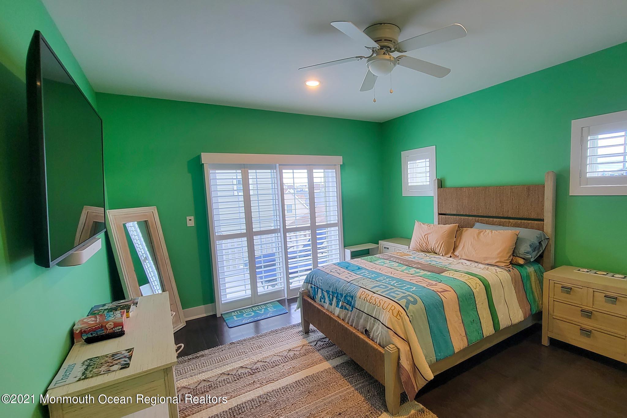 13 Surf Road Seaside Heights, NJ 08751 - Photo 38 of 64 a bedroom with a bed a flat screen tv and a large window