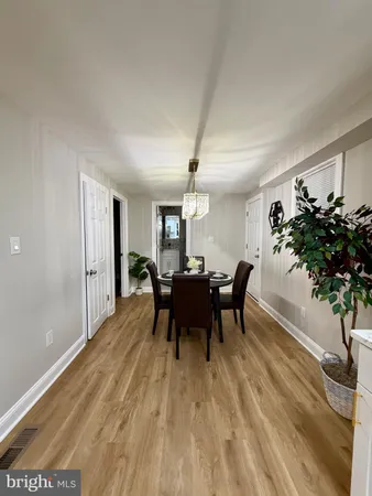 a dining room with furniture potted plants and wooden floor