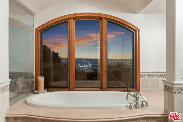 a bedroom with a bed and a large window with outer view