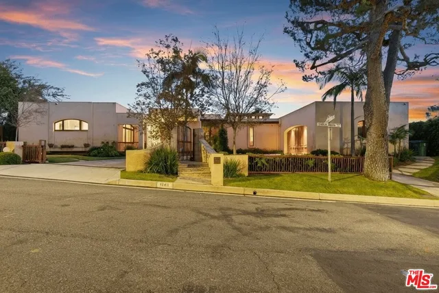 a view of a house with a big yard and large trees