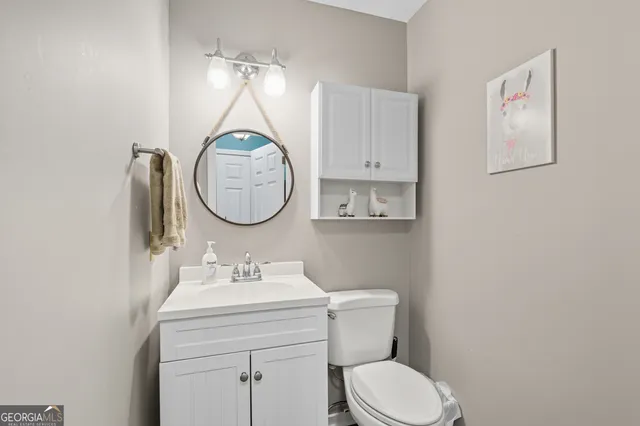 a bathroom with a toilet a sink and a mirror