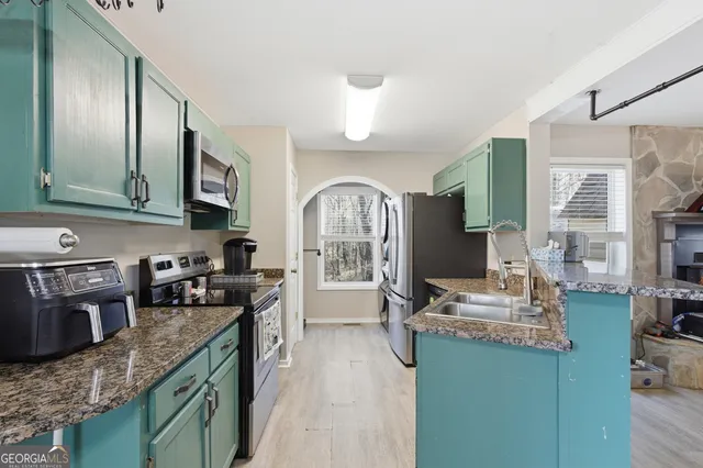 a kitchen with granite countertop a stove top oven microwave and cabinets