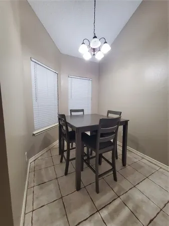 a view of a dining room with a table and chairs
