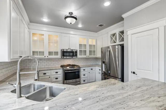 a kitchen with stainless steel appliances granite countertop a sink stove and refrigerator