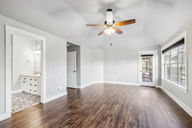 a spacious bathroom with a granite countertop sink a mirror and a shower