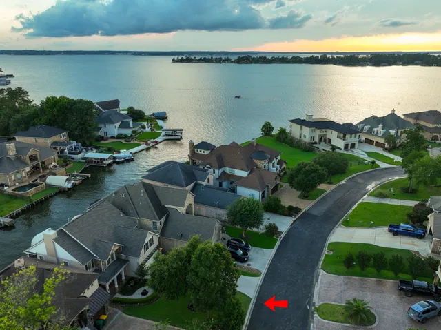 an aerial view of a house with a yard and lake view