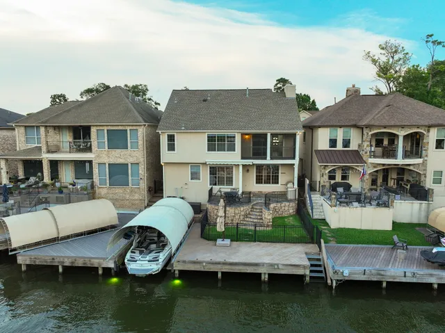 an aerial view of ocean and residential houses with outdoor space