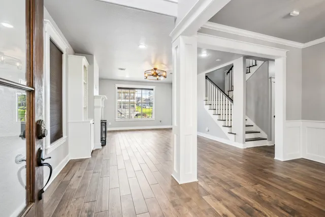 a view of a hallway with wooden floor and stairs