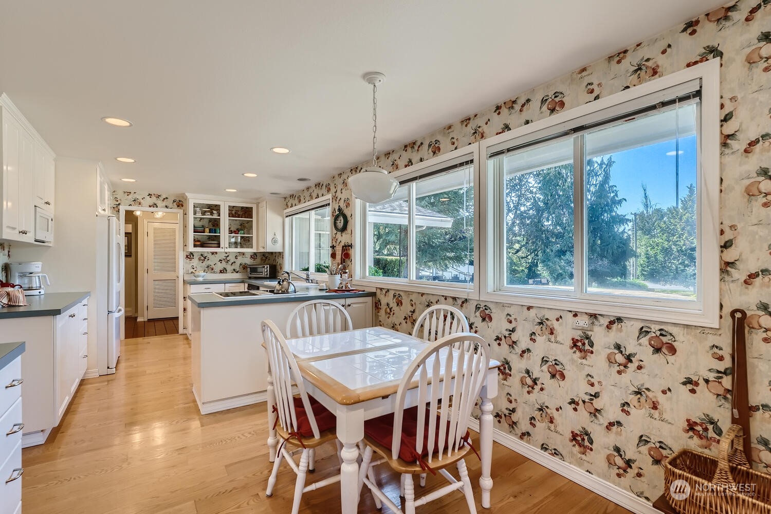 12823 Spanaway Loop Road South Tacoma, WA 98444 - Photo 13 of 38 a view of a kitchen with kitchen island granite countertop a dining table chairs stainless steel appliances and a large window