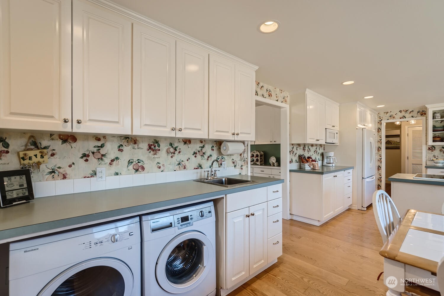 12823 Spanaway Loop Road South Tacoma, WA 98444 - Photo 14 of 38 a view of kitchen with stainless steel appliances granite countertop a stove a sink a refrigerator and white cabinets with wooden floor