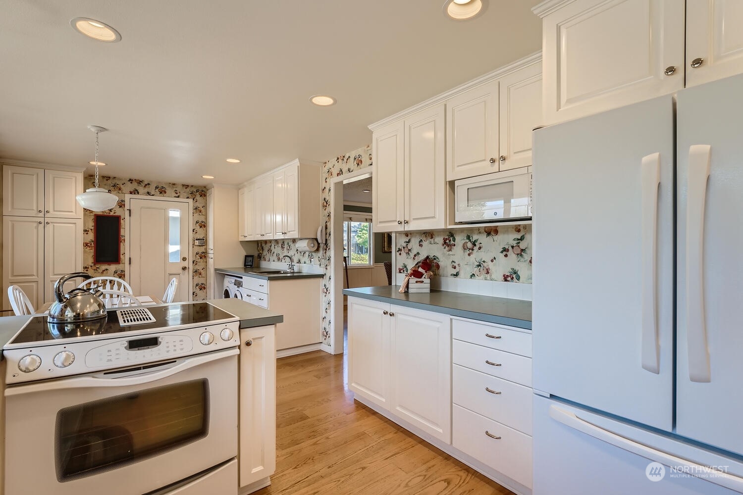 12823 Spanaway Loop Road South Tacoma, WA 98444 - Photo 10 of 38 a kitchen with white cabinets and white appliances
