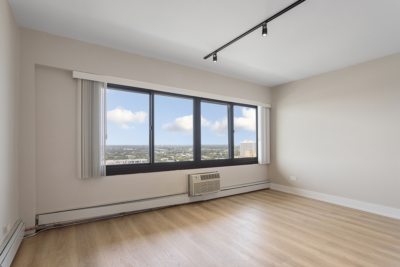 6166 North Sheridan Road, Unit 22B Chicago, IL 60660 - Photo 10 of 18 an empty room with wooden floor and windows