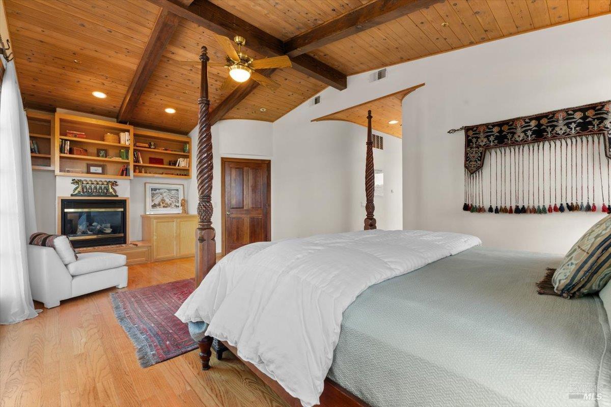 13404 Flora Ranch Road Healdsburg, CA 95448 - Photo 34 of 66 a spacious bedroom with a bed a flat screen tv and couches