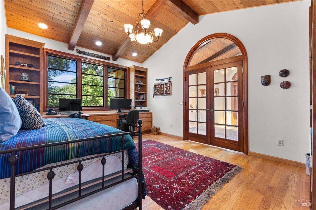 13404 Flora Ranch Road Healdsburg, CA 95448 - Photo 41 of 66 a spacious bedroom with a bed a table and large windows