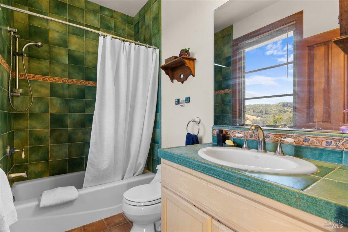 13404 Flora Ranch Road Healdsburg, CA 95448 - Photo 45 of 66 a bathroom with a granite countertop sink toilet and shower