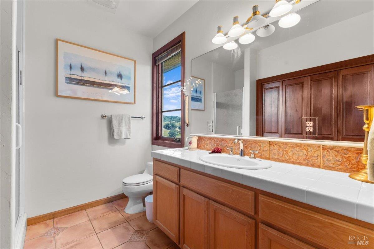 13404 Flora Ranch Road Healdsburg, CA 95448 - Photo 46 of 66 a bathroom with a sink a toilet and a mirror