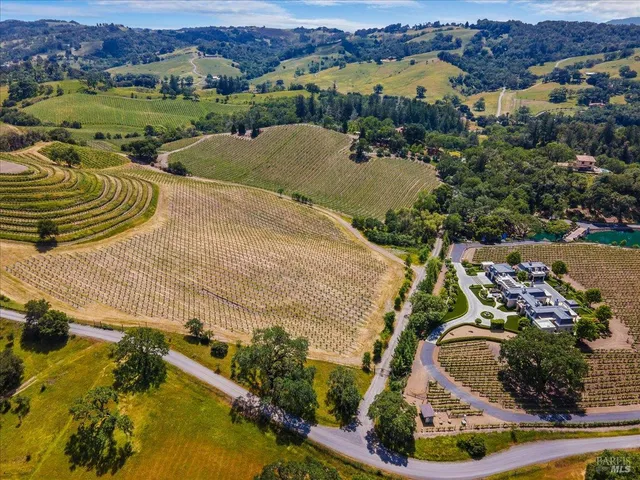 an aerial view of a house with a yard and lake view