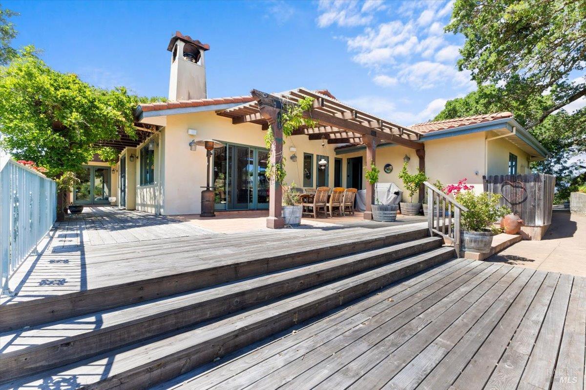 13404 Flora Ranch Road Healdsburg, CA 95448 - Photo 51 of 66 a view of a house with entrance stairs and a table and chairs