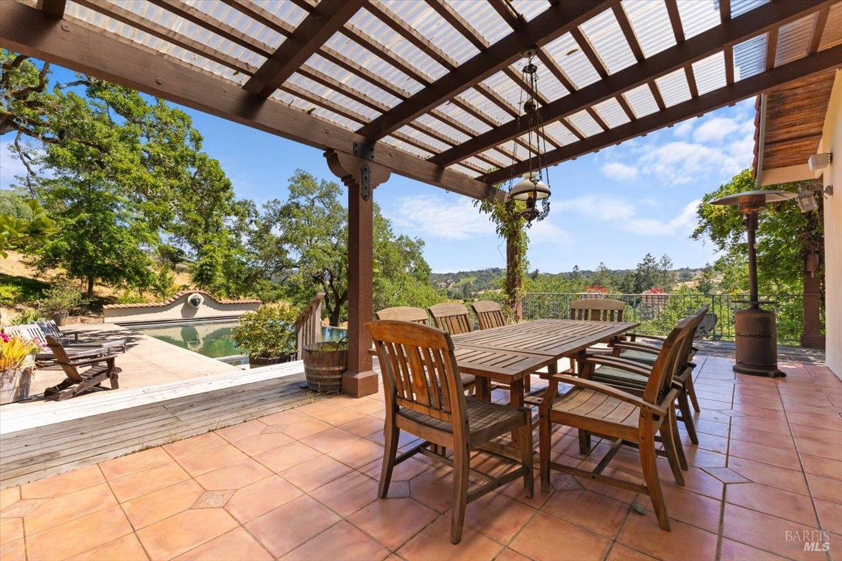 13404 Flora Ranch Road Healdsburg, CA 95448 - Photo 55 of 66 a view of a patio with table and chairs and potted plants