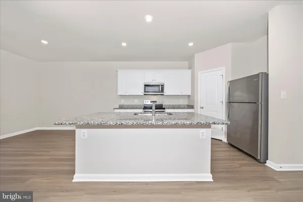 a kitchen with stainless steel appliances granite countertop a sink and a refrigerator