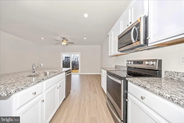 a kitchen with stainless steel appliances granite countertop a sink and stove top oven