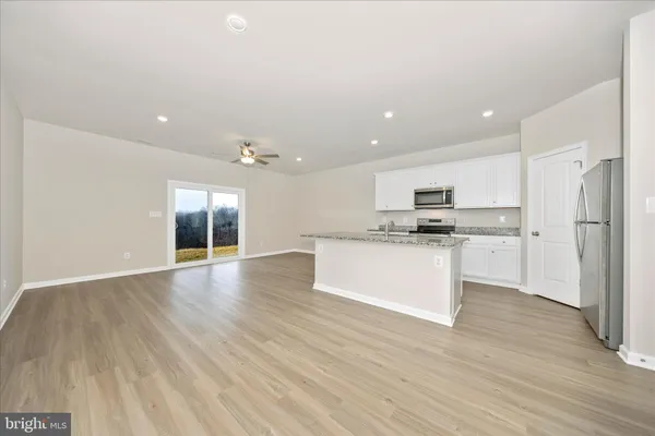 a view of kitchen with granite countertop stainless steel appliances refrigerator sink and cabinets