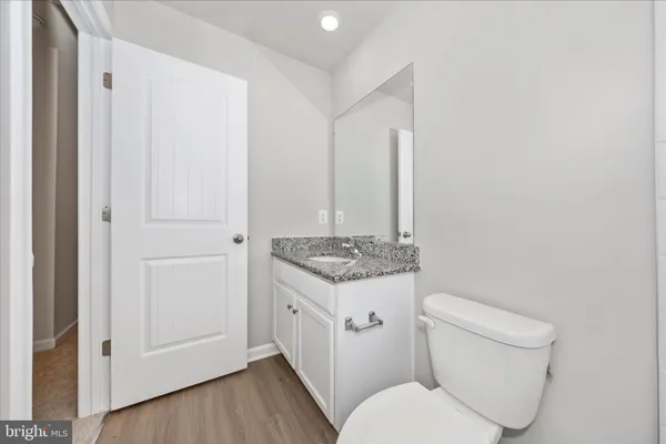 a bathroom with a granite countertop toilet and a sink
