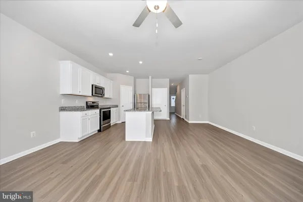 a view of kitchen with refrigerator microwave and stove top oven