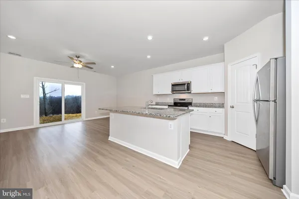 a kitchen with a refrigerator and white cabinets