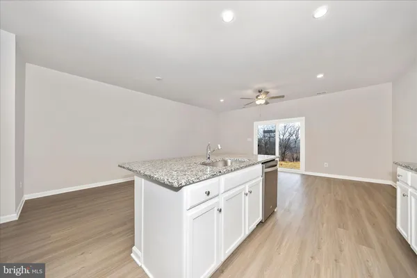 a kitchen with a sink and wooden floor